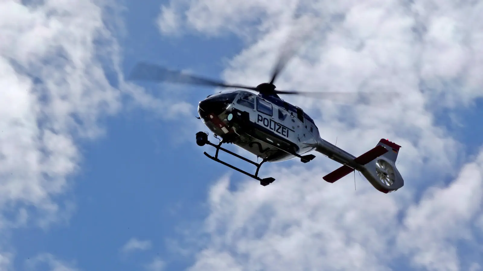 Ein Hubschrauber mit Wärmebildkamera beteiligt sich ebenfalls an der Suche nach dem 19-Jährigen. (Symbolbild: Jan Woitas/dpa)