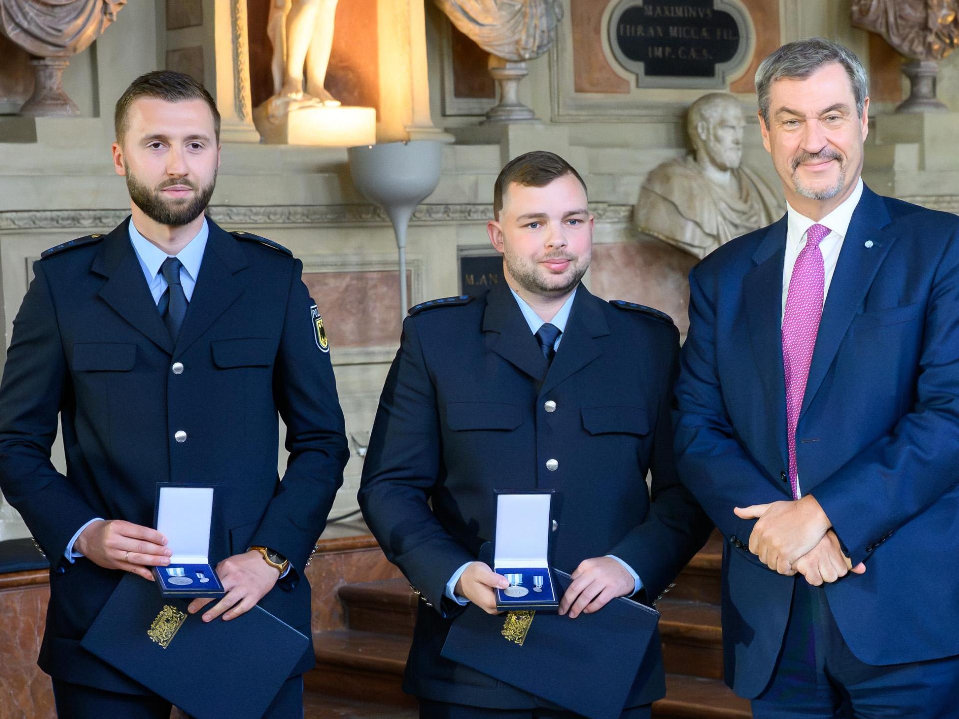 Christian Ach und Johannes Weigandt (von links) haben von Ministerpräsident Markus Söder Bayerische Rettungsmedaille erhalten. (Bild: Joerg Koch/Bayerische Staatskanzlei)